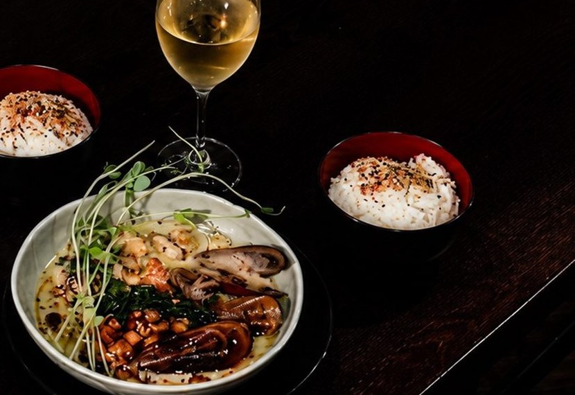 A shared bowl with steamed rice and a glass of white wine